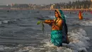 Umat Hindu India berdoa sambil berdiri di perairan Laut Arab saat matahari terbenam selama Festival Chhath di Mumbai, Selasa (13/11). Festival Hindu kuno ini bentuk terima kasih kepada Dewa Matahari yang menopang kehidupan di bumi. (AP/Rafiq Maqbool)