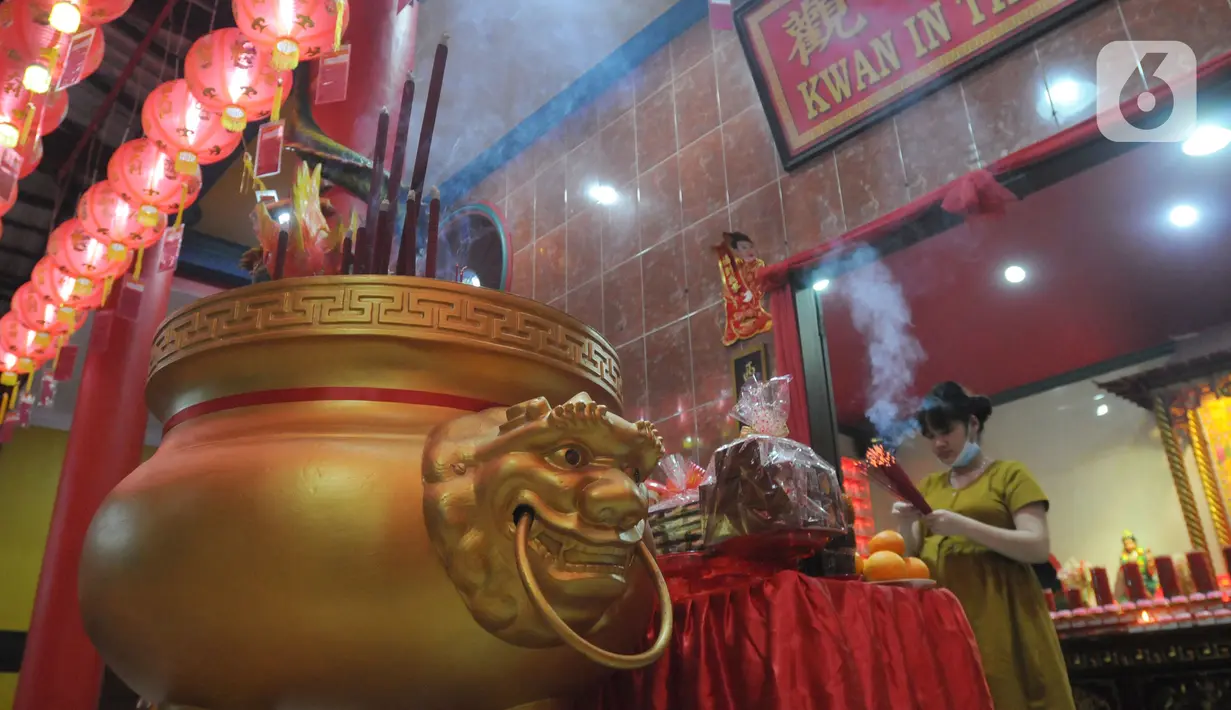 Warga keturunan Tionghoa membawa hio (dupa) pada malam tahun baru Imlek 2573 di  Vihara Kwan In Thang, Pondok Cabe, Tangerang Selatan, Senin (31/1/2022). Perayaan malam Imlek berlangsung khidmat dan sederhana di tengah merebaknya covid-19 varian omicron. (merdeka.com/Arie Basuki)