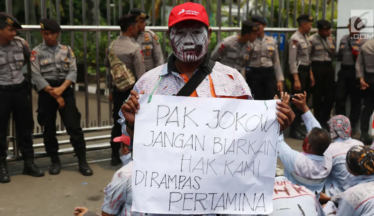 Seorang pria ikut menggelar aksi di depan gedung Pertamina, Jakarta, Senin (23/10). Aksi ini untuk menuntut hak atas PHK yang terjadi kepada mereka yang dilakukan oleh PT Pertamina Patra Niaga dan Elnusa Petrofin. (Liputan6.com/Angga Yuniar)