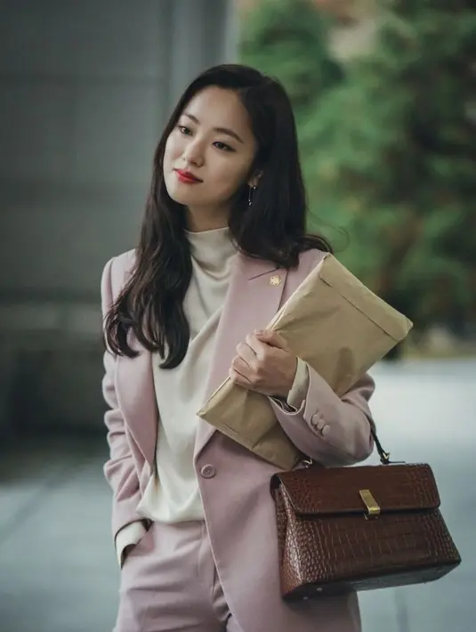 Hong Cha Young yang diperankan Jeon Yeo Bin di drama Vincenzo kerap tampil dengan power suits. Sesekali ia memainkan warna, sehingga outfit kantornya tak membosankan. (twitter/iiiaaaamiiii).