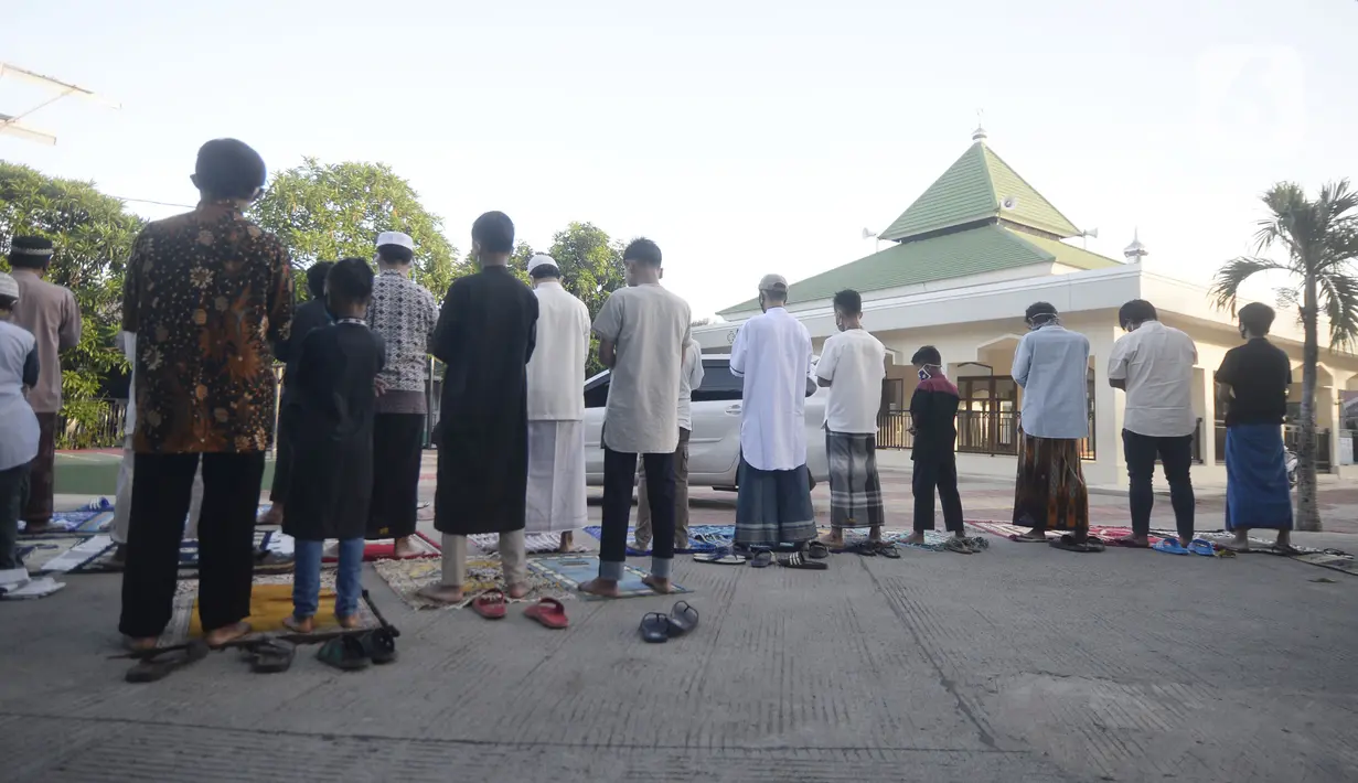 Jemaah melaksanakan salat Idul Fitri di pelataran Masjid Al Kahfi Griya Pamulang 2, Parakan, Pamulang, Tangerang Selatan, Banten, Minggu (24/5/2020). Di tengah pandemi virus corona COVID-19, jemaah yang hadir mengenakan masker untuk mencegah penularan. (merdeka.com/Dwi Narwoko)