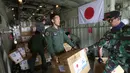 Personil militer Jepang dibantu TNI mengangkut bantuan logistik untuk korban gempa dan tsunami dari sebuah pesawat kargo Angkatan Udara Jepang di bandara Mutiara Sis Al-Jufri di Palu, Sulawesi Tengah, Indonesia (6/10). (AP Photo/Tatan Syuflana)
