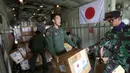 Personil militer Jepang dibantu TNI mengangkut bantuan logistik untuk korban gempa dan tsunami dari sebuah pesawat kargo Angkatan Udara Jepang di bandara Mutiara Sis Al-Jufri di Palu, Sulawesi Tengah, Indonesia (6/10). (AP Photo/Tatan Syuflana)