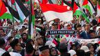 Para demonstran mengibarkan bendera Indonesia dan Palestina selama aksi unjuk rasa solidaritas untuk warga Palestina di Gaza, di Jakarta, Minggu 12 Oktober 2025. (AP Photo/Tatan Syuflana)