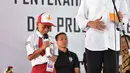 Presiden Jokowi memberikan pertanyaan kepada seorang siswa saat penyerahan KIP dan PKH di SMA Negeri 1 Palembang, Sumatra Selatan (22/1). Presiden Jokowi mengingatkan agar bantuan tersebut dipergunakan sebagaimana mestinya.(Liputan6.com/Pool/Biro Setpres)