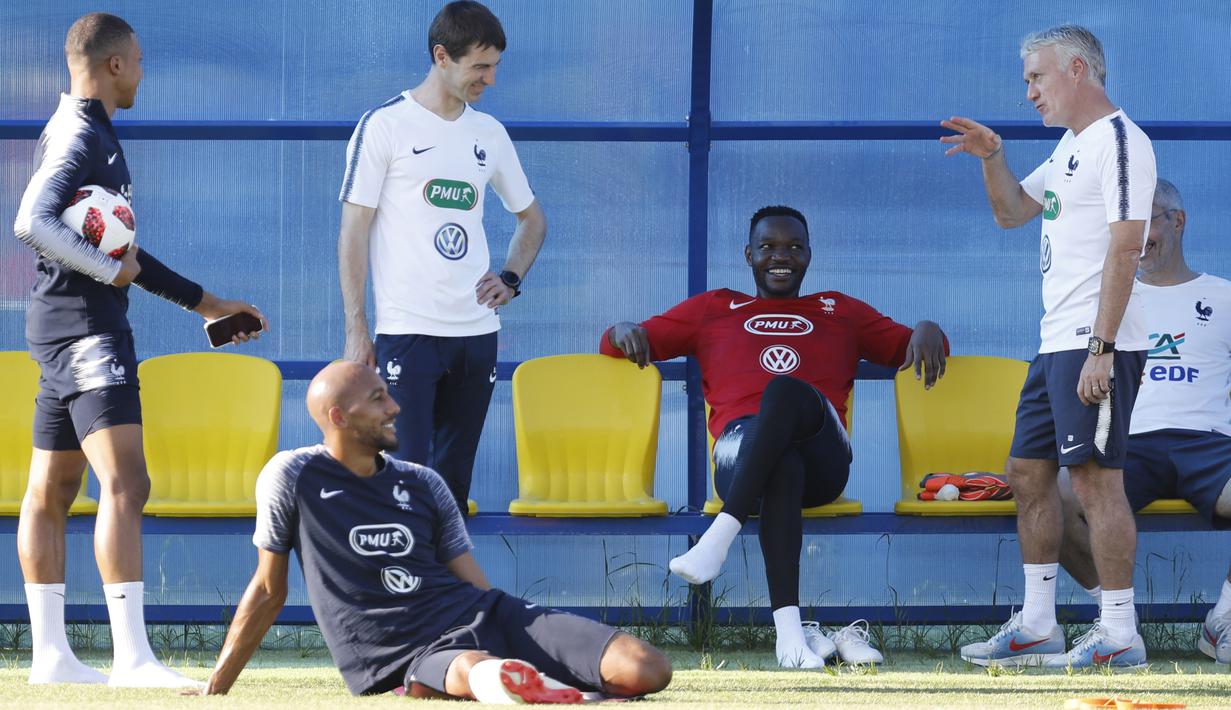 Pelatih Didier Deschamps berbincang santai dengan pemain Prancis sebelum sesi latihan di Glebovets, Rusia, (12/7/2018). Latihan tersebut sebagai persiapan Prancis melawan Kroasia pada Final Piala Dunia 2018. (AP/David Vincent)