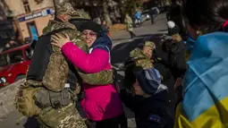 Seorang warga Kherson memeluk anggota pasukan pertahanan Ukraina di Kherson, Ukraina selatan, Senin (14/11/2022). Kherson adalah satu-satunya ibu kota regional yang direbut Rusia setelah invasi Februari. (AP Photo/Bernat Armangue)