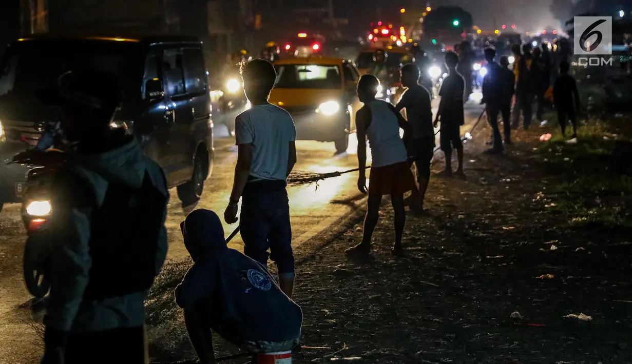 Sejumlah penyapu koin kali Sewo menunggu uang yang dilemparkan oleh pengguna jalan yang melintasi Jembatan Sewo, Kabupaten Indramayu, Jawa Barat, Minggu (2/7). (Liputan6.com/Faizal Fanani)