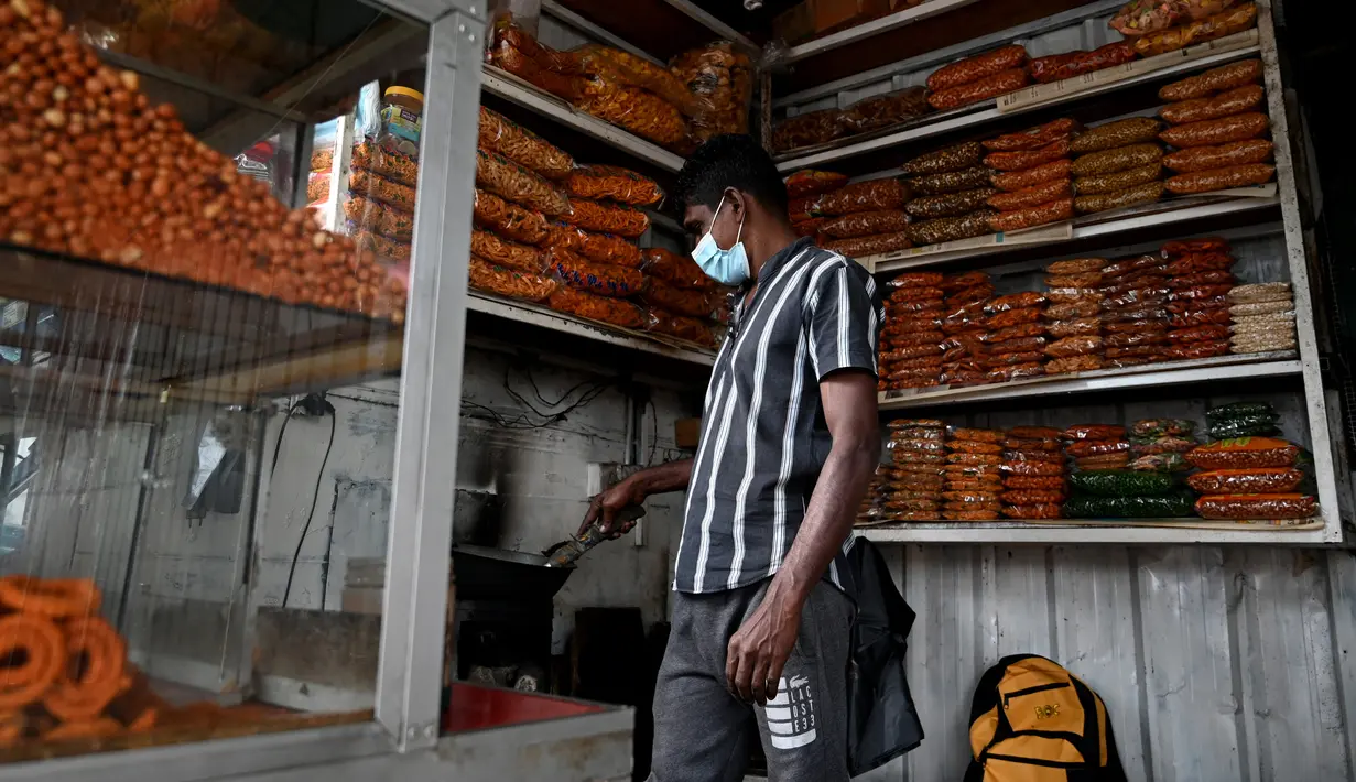Penjual menyiapkan kacang di tokonya setelah pemadaman listrik di Kolombo, Rabu (2/3/2022). Sri Lanka mengumumkan pemadaman listrik setiap hari selama 7,5 jam, terlama dalam lebih dari seperempat abad, karena krisis valuta asing membuatnya tidak dapat mengimpor minyak. (Ishara S. KODIKARA/AFP)