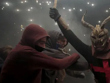 Seorang warga berpakaian seperti hantu dengan memegang tongkat kembang api selama perayaan " Correfocs ", Mallorca, Spanyol, (24/1). Ini merupakan perayaan tradisional yang menandai menandai akhir dari perayaan lokal di Palma. (REUTERS / Enrique Calvo)