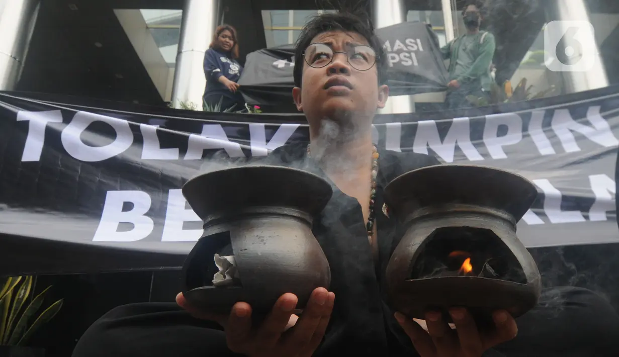 Aksi teatrikal aktivis dari Indonesia Corruption Watch (ICW) untuk menolak kehadiran pimpinan KPK bermasalah di depan Gedung Merah Putih KPK, Jakarta, Jumat (20/12/2019). Aksi penolakan digambarkan dengan keberadaan dua dukun yang tengah mengusir roh jahat. (merdeka.com/Dwi Narwoko)
