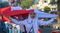 Ribuan pelajar turun ke jalan untuk mengikuti prosesi upacara dan arak-arakan bendera Merah Putih. (Juni KRISWANTO/AFP)