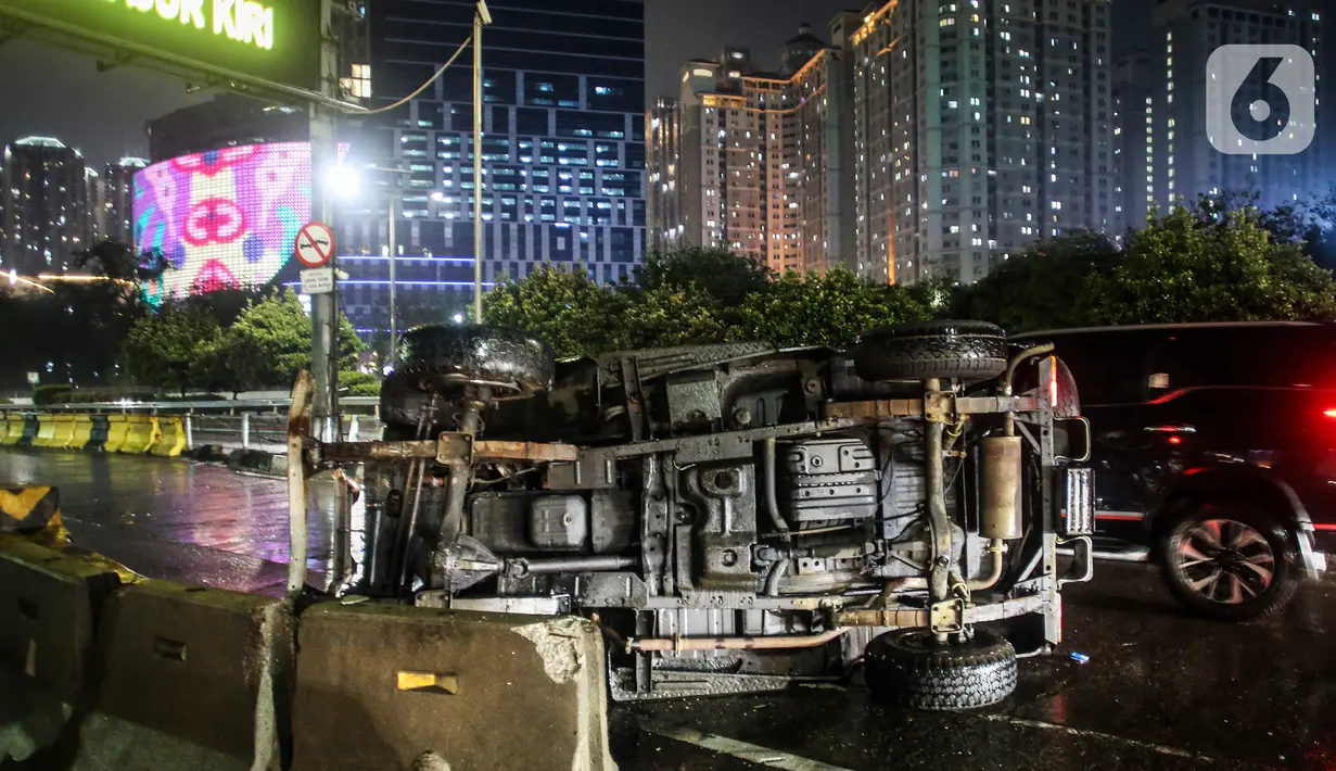 Kendaraan melintas di samping mobil jenis jeep yang terguling di depan gerbang Tol Tanjung Duren, Jalan S Parman, Jakarta Barat, Minggu (26/9/2021). Tidak ada korban jiwa, namun kecelakaan tersebut membuat lalu lintas di jalan itu terimbas kemacetan yang cukup panjang. (Liputan6.com/Johan Tallo)