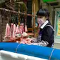 Seorang wanita membeli daging di Wuhan, ibu kota Provinsi Hubei, China tengah, (16/4/2020). Seiring meredanya epidemi COVID-19, kehidupan berangsur kembali normal di Wuhan. (Xinhua/Shen Bohan)