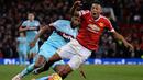 Pemain MU, Anthony Martial, menghindari tekel pemain West Ham, Alex Song pada laga Liga Premier Inggris di Stadion Old Trafford, Inggris, Sabtu (5/12/2015). (AFP Photo/Oli Scarff)