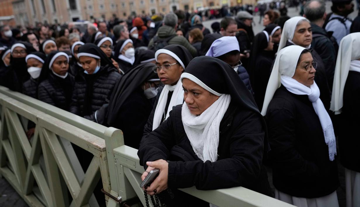 Orang-orang mengantre untuk memasuki Basilika Santo Petrus tempat mendiang Paus Emeritus Benediktus XVI disemayamkan di Vatikan, Senin (2/1/2023). Benediktus XVI, teolog Jerman yang akan dikenang sebagai paus pertama dalam 600 tahun yang mengundurkan diri, telah meninggal pada 31 Desember 2022 di usia 95 tahun. (AP Photo/Alessandra Tarantino)