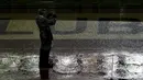 Seorang petugas mengambil gambar lapangan Stadion Monumental, Buenos Aires, Argentina, yang tergenang sebelum laga Kualifikasi Piala Dunia 2018 antara Argentina melawan Brasil ditunda. Jumat (13/11/2015) WIB. (Reuters/Marcos Brindicci)