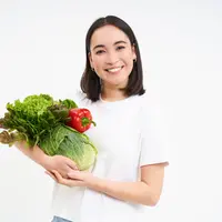 Seorang perempuan memegang sayur-sayuran di tangannya (Foto Dok: Freepik/benzoix).