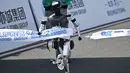 Sebuah robot melintasi garis finis dalam lomba lari setengah maraton robot humanoid di Beijing pada 19 April 2025. (Pedro PARDO/AFP)