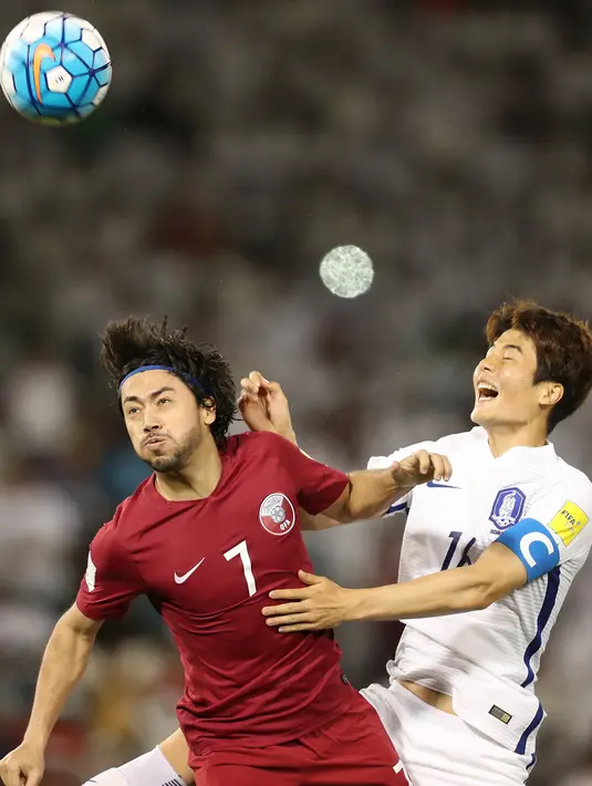 Pemain Qatar, Rodrigo Tabata (kiri)  berebut bola udara dengan pemain Korea Selatan Han Kookyoung saat bertanding dalam Kualifikasi Piala Dunia 2018 di stadion Jassim Bin Hamad, Doha, Qatar, (13/6). Qatar menang atas Korsel 3-2. (AFP Photo/Karim Jaafar)