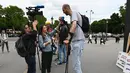 Wartawan saat mewawancarai Brahim Takioullah yang memiliki tinggi tubuh 2 meter 46 centimeter saat berkumpul dengan orang-orang tertinggi dunia di Champs-Elysees Avenue di Paris, Prancis (14/6/2019). (AFP Photo/Dominique Faget)