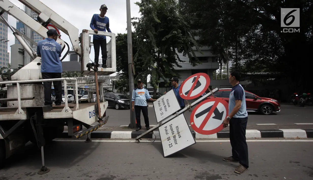 Petugas Dishub DKI mengangkut rambu rambu larangan sepeda motor melintasi Jalan MH Thamrin, Jakarta Pusat, Rabu (10/1). Tidak ada penjagaan petugas di perlintasan Jalan MH Thamrin. (Liputan6.com/Arya Manggala)