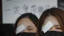 Seorang perawat mengenakan penutup mata dan masker mengambil bagian dalam protes terhadap kebrutalan polisi terhadap para pengunjuk rasa di sebuah rumah sakit di Hong Kong (13/8/2019). (AP Photo/Kin Cheung)