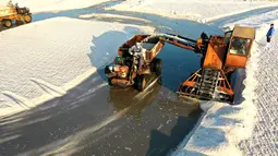 Foto dari udara yang diabadikan pada 4 November 2020 ini menunjukkan para pekerja mengumpulkan garam di sebuah tambak garam di ladang garam Dongfeng di Qingdao, Provinsi Shandong, China timur. Ladang garam Dongfeng telah memasuki musim panen baru-baru ini. (Xinhua/Liang Xiaopeng)