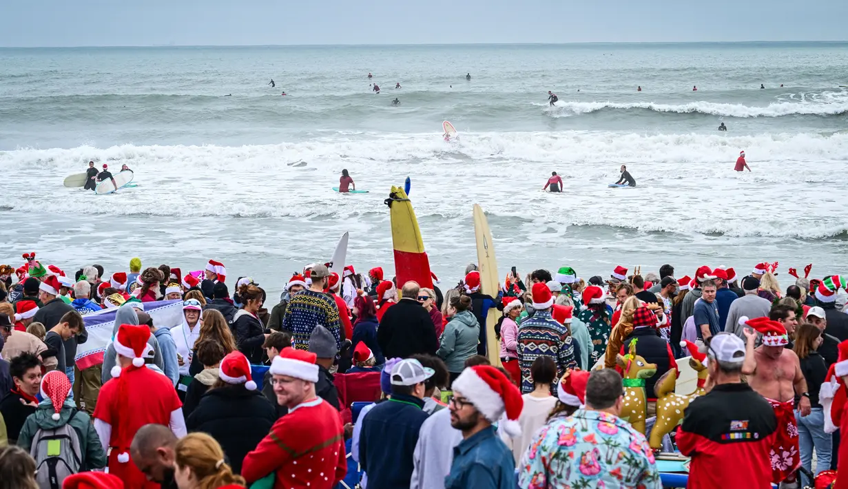 Pengunjung memadati acara Surfing Santa yang berlangsung di Pantai Cocoa, Florida, Amerika Serikat, Selasa (24/12/2024) waktu setempat. (AFP/Giorgio Viera)