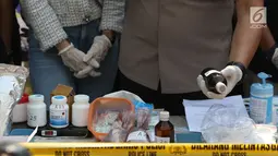 Petugas menunjukkan barang bukti bahan pembuat narkoba saat rilis di sebuah perumahan di Pondok Rajeg, Cibinong, Senin (24/9). Polisi menyita sejumlah barang bukti diantaranya 158 gram sabu, 3000 pil ekstasi. (Liputan6.com/Helmi Fithriansyah)