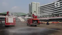 Petugas pemadam kebakaran menyemprotkan cairan disinfektan di Kompleks Parlemen, Senayan, Jakarta, Minggu (9/8/2020). Penyemprotan cairan disinfektan tersebut dilakukan dalam rangka pencegahan penyebaran virus Corona (COVID-19) di lingkungan DPR/MPR. (Liputan6.com/Johan Tallo)