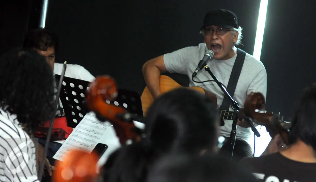 Musisi legendaris, Iwan Fals menjalani sesi latihan bersama Erwin Gutawa Orchestra, Jakarta, Minggu (21/8). Iwan Fals menuturkan akan menampilkan sajian yang spektakuler di HUT SCTV ke-26 dengan iringan musik orkestra. (Liputan6.com/Helmi Afandi)
