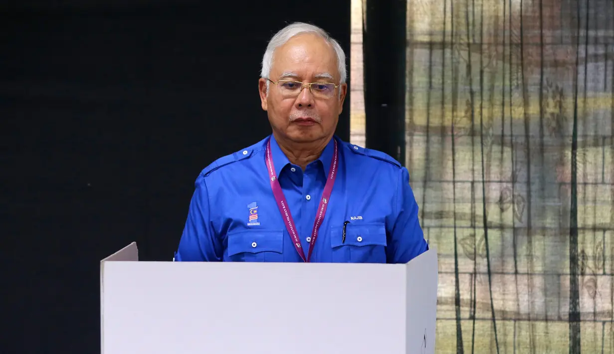 Perdana Menteri Malaysia, Najib Razak mencoblos di bilik suara pada pemilihan umum (Pemilu) di TPS wilayah Pekan, Pahang, Rabu (9/5). Pemilu ini pertarungan antara PM Najib yang sudah berkuasa sejak 2009, melawan Mahathir Mohamad. (AP/Aaron Favila)