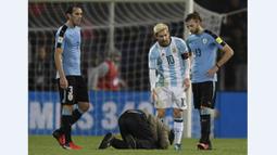  Seorang penggemar berusaha mencium kaki Lionel Messi saat laga Kualifikasi Piala Dunia 2018 antara Argentina melawan Uruguay di Mendoza, Argentina, (1/9/2016). (AFP/Juan Mabromata)