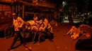 Sejumlah buruh mengangkut barang dengan gerobak di kawasan tua New Delhi, India (6/3). Karena tuntutan ekonomi para buruh India ini harus rela hidup seadanya, bahkan mereka masih bekerja hingga larut malam. (AFP Photo/Chandan Khanna)