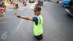 Pak Mamat (73 tahun) tengah mengatur arus lalu lintas di Jalan Raya Ciracas, Jakarta, Minggu (20/9/2015). Cacat fisik sejak lahir tidak membuat pria asli warga Ciracas ini putus harapan dalam menghidupi keluarganya. (Liputan6.com/Faizal Fanani)