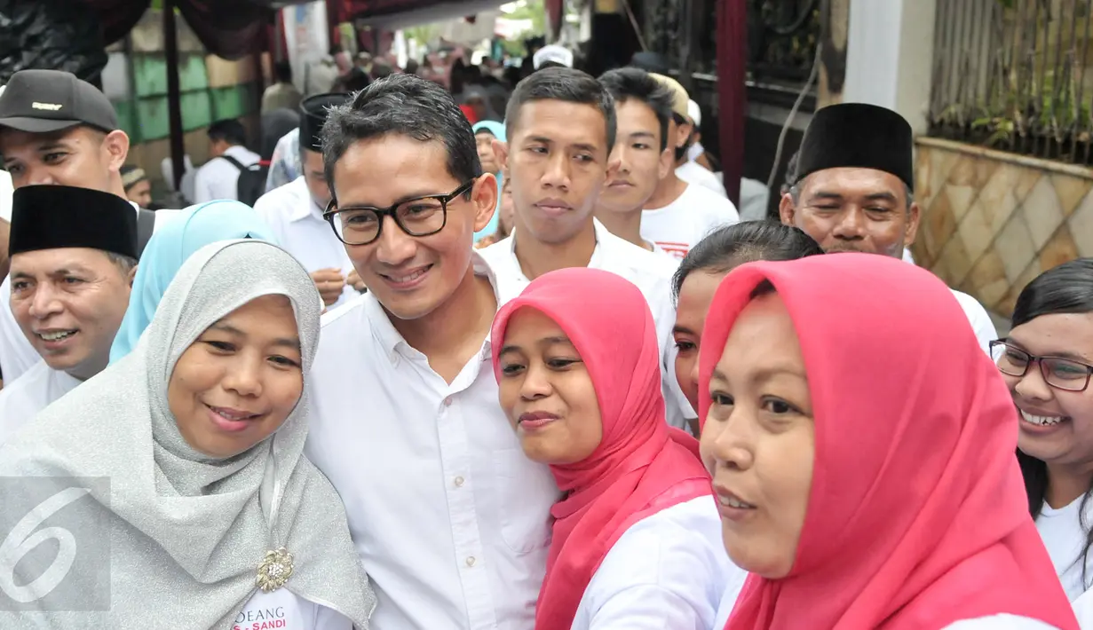 Warga foto bersama Cawagub DKI Jakarta, Sandiaga Uno saat sosialisasi di Jalan Batu Ampar, Kramatjati, Jakarta Timur, Senin (3/4). Selain sosialisasi, Sandi melantik kader Roemah Djoeang pemenangan di wilayah Batu Ampar. (Liputan6.com/Yoppy Renato)