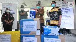 Trade & Visibility Manager Saint Gobain Group Yudi Surahman menyerahkan APD (Alat Pelindung Diri) kepada Kepala Sudin Kesehatan Jakarta Selatan M. Helmi untuk tenaga medis di 8 RSUD di Jakarta Selatan di Jakarta, Kamis (2/4/2020). (Liputan6.com/HO/Iwan)