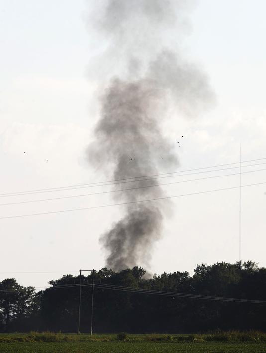 Kepulan asap mengudara dari lokasi jatuhnya sebuah pesawat militer milik AS di wilayah Sunflower-Leflore, Mississippi, Senin (10/7). Pesawat militer yang mengalami kecelakaan diketahui berjenis C-130 Hercules milik Korps Marinir AS (AP Photo/Andy Lo)