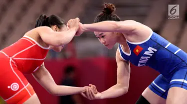 Pegulat Indonesia, Ulfah Dewi (kiri) bertarung dengan pegulat Vietnam, Pham Thi Ha Phuong pada babak perdelapan final Freestyle 53 kg putri dalam Asian Games 2018 di JCC Senayan, Senin (20/8). Ulfah Dewi kalah dengan skor 3-5. (Liputan6.com/Fery Pradolo)