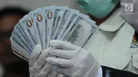 Petugas KPK menunjukkan barang bukti uang pecahan dollar hasil operasi tangkap tangan Bupati Jombang, Nyono Suharli Wihandoko di Gedung KPK, Jakarta, Minggu (4/2). KPK menyita uang Rp 25,5 Juta dan 9.500 US Dollar. (Liputan6.com/Helmi Fithriansyah)