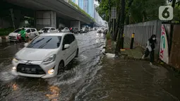 Kendaraan melintasi genangan air di Jalan Gatot Subroto, Jakarta, Kamis (18/2/2021). Hujan deras yang mengguyur wilayah Jakarta menyebabkan terjadinya genangan di beberapa ruas jalan, meski begitu sejauh ini kendaraan masih dapat melintas. (Liputan6.com/Faizal Fanani)