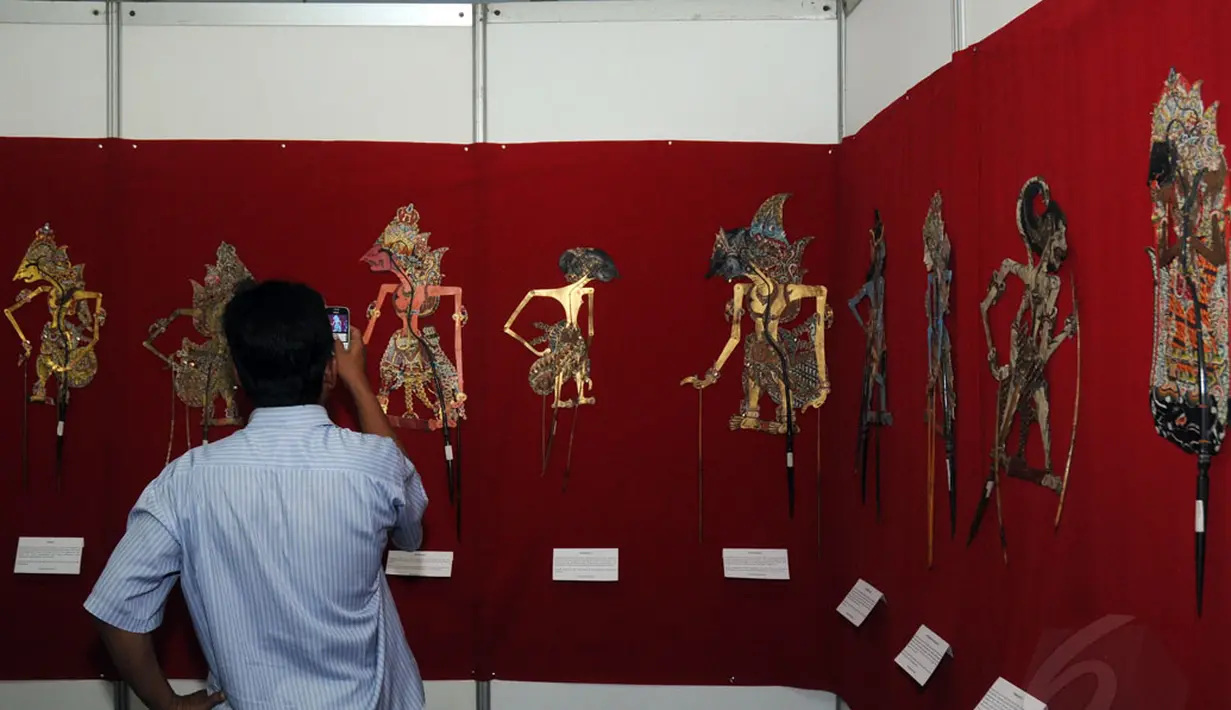 Festival Wayang Goes To Campus 2014 berlangsung hingga 27 September 2014 mendatang. Tampak, salah satu pengunjung mengabadikan tokoh wayang yang dipamerkan di Balairung Universitas Indonesia, Depok, (24/9/2014). (Liputan6.com/Helmi Fithriansyah)