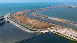 Proyek ini memiliki fungsi ganda, pertama sebagai jalan tol untuk mengurangi kemacetan dan kedua, menjadi tanggul laut untuk menanggulangi banjir rob serta penurunan muka tanah. Tampak dalam foto udara menunjukkan pembangunan Jalan Tol Laut Semarang-Demak, sebuah mega-proyek nasional yang dirancang untuk mengatasi banjir pasang surut air laut yang sering terjadi di sepanjang pantai utara, di Semarang, Jawa Tengah, pada Minggu 19 April 2026. (DEVI RAHMAN/AFP)