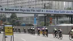 Para pebalap melintasi jembatan penyebrangan dengan jarak 1km sebelum garis finish pada ajang Tour de Jakarta di Jakarta, Sabtu (30/7/2016). (Bola.com/Nicklas Hanoatubun)