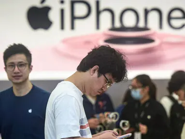 Seorang pria mencoba ponsel iPhone 15 yang baru saja diluncurkan di sebuah toko Apple di Hangzhou, di provinsi Zhejiang, China pada 22 September 2023. (AFP/China OUT)