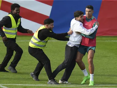 Seorang penggemar menempel pada penyerang Portugal Cristiano Ronaldo selama sesi latihan di Gutersloh, Jerman, Jumat, 14 Juni 2024. (AP Photo/Hassan Ammar)