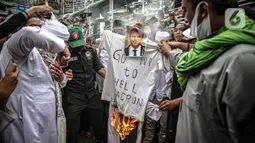 Massa dari berbagai elemen ormas Islam membakar atribut dengan foto Presiden Prancis Emmanuel Marcon di kawasan Sarinah, Jakarta, Senin (2/11/2020). Demonstrasi ini untuk mengecam Emanuel Macron atas pernyataannya yang dinilai telah menghina Islam dan Nabi Muhammad SAW. (Liputan6.com/Faizal Fanani)