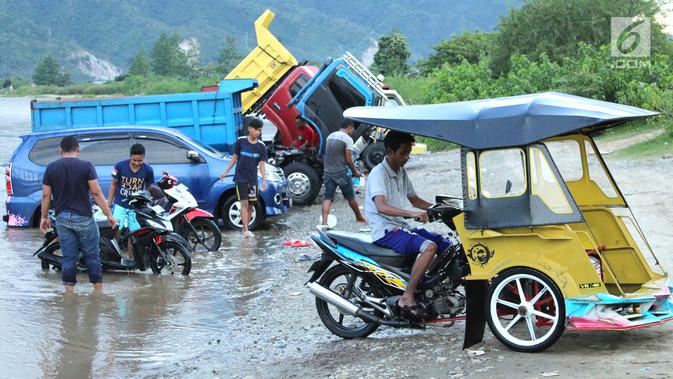 Pengendara memacu becak motor seusai mencuci kendaraannya di sungai Bone, kompleks Jembatan Talumolo II, Kelurahan Talumolo, Gorontalo, Senin (19/11). Tempat itu menjadi kawasan pencucian kendaraan bermotor yang gratis.  (Liputan6.com/Arfandi Ibrahim)