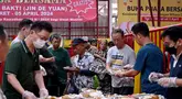 Para jemaat kelenteng Jin De Yuan membagikan makanan gratis kepada umat Muslim yang bersiap untuk berbuka puasa selama bulan suci Ramadan di Jakarta pada 18 Maret 2024. (Adek BERRY/AFP)